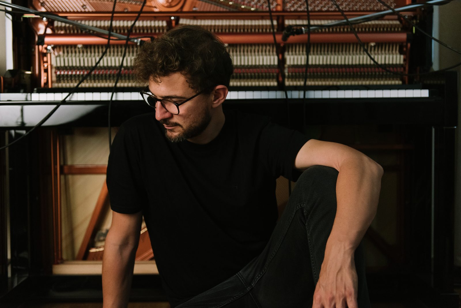 Claudio Donzelli sitting in front of an open piano